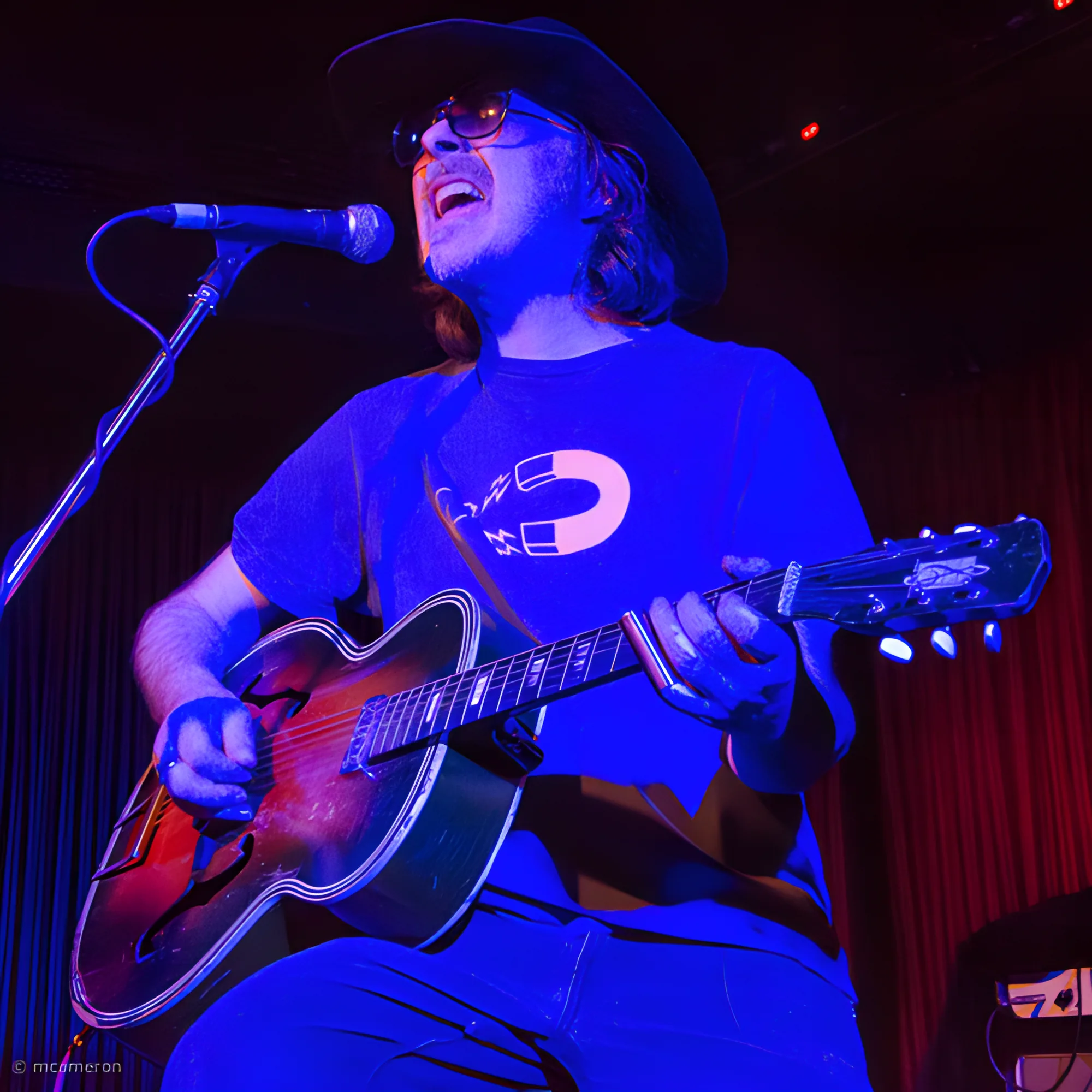 Tim Gibbons singing with an acoustic guitar